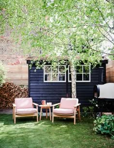 two chairs and a table sitting in the grass