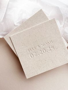 two wedding coasters with the names and date printed on them, sitting next to each other