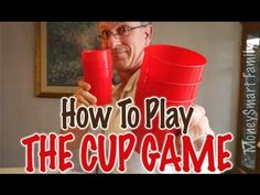 an old man holding two red cups with the words how to play the cup game