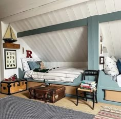 an attic bedroom with two beds and suitcases