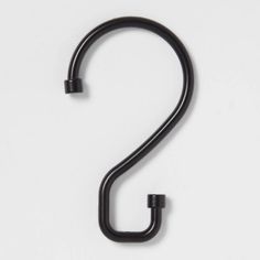 a black metal hook on a white background with the letter s in it's center