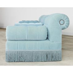 a light blue chair with fringe trim on it