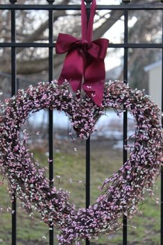 a heart shaped wreath hanging on a gate