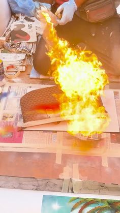 a person sitting on the ground with a fireball in their hand and papers around them