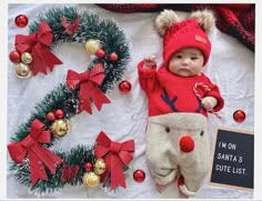 a baby laying on top of a blanket next to christmas decorations