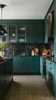 a kitchen with green cabinets and black counter tops