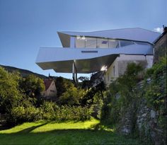 an unusual house in the middle of a lush green field