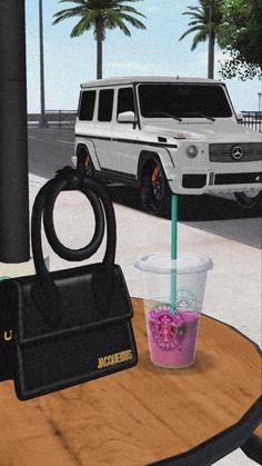 a table with a drink, handbag and purse on it next to a car