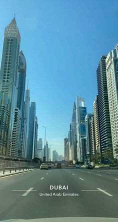 an empty street with tall buildings in the background and a sign that says, dubai united arab emirates