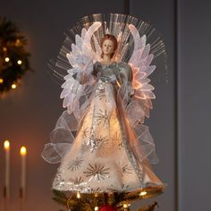 an angel figurine on top of a christmas tree