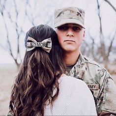 a soldier hugging a woman with two bows in her hair and the caption says, i love someone