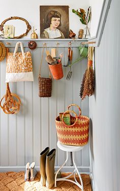 there are many items hanging on the wall in this room, including boots and purses