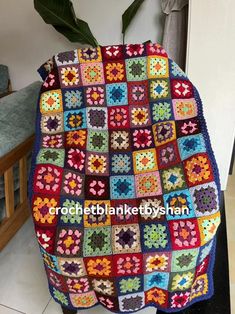 a crocheted blanket sitting on top of a chair