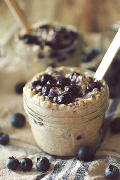 a jar filled with oatmeal and blueberries on top of a table