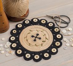 a table topped with lots of different types of buttons and yarn next to some scissors