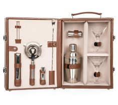 an open suitcase with various items in it on a white background, including a cocktail shaker and two martini glasses