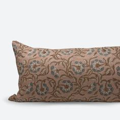 a brown and blue floral pillow on a white background with an embroidered design in the middle