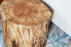 a wooden stump sitting on top of a rug