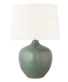 a green vase with a white shade on it's side and a light in the middle