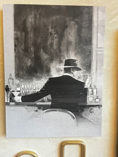 a black and white photo of a man in a top hat sitting at a bar