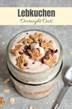 a glass jar filled with cereal and topped with milk next to a spoon on top of a table