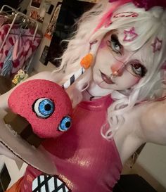 a woman dressed as a monster holding a stuffed animal