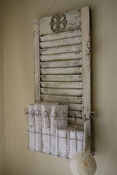 an old window is hung on the wall with some towels and a ball hanging from it