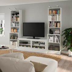 a living room filled with furniture and a flat screen tv on top of a book shelf