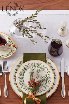 the place setting is decorated with holly and berries