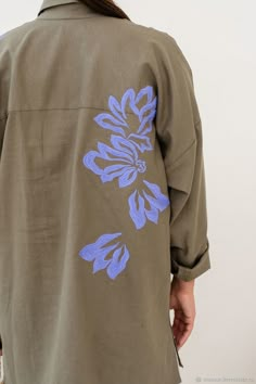 a person wearing a brown shirt with blue flowers on it