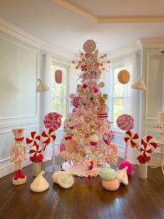 a pink christmas tree decorated with lollipops, candy canes and candies