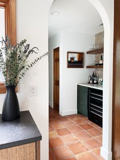 a vase filled with flowers sitting on top of a counter next to a sink and oven