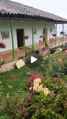 an image of a house with flowers in the front yard and on the other side