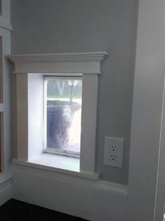 an empty room with a window and some electrical outlets on the wall next to it