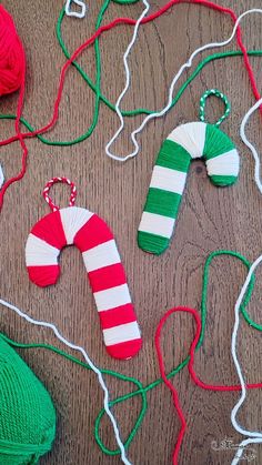 several knitted christmas ornaments are laid out on the floor, including one green and white striped ornament