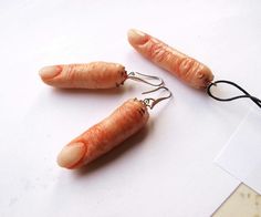 three small carrots are hanging from earwires