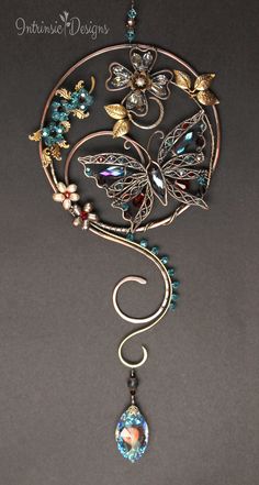 a metal wind chime with butterflies and beads hanging from it's centerpiece