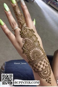 a woman's hand with henna tattoos on it