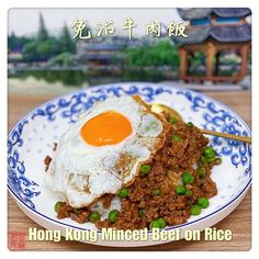 a plate with meat and an egg on it, in front of a chinese background