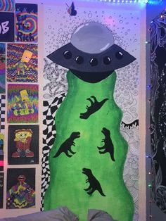 a bedroom decorated in green and black with pictures on the wall, dinosaurs are flying around