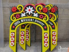 an arch that has flowers on it and the words twin mexico written in red, white, and green