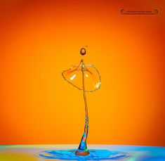 an orange and blue background with water splashing on the surface, as if it were floating