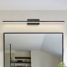 a bathroom mirror sitting above a sink under a faucet mounted on a wall