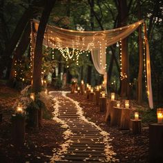 an outdoor wedding with candles and lights on the path to the ceremony venue in the woods