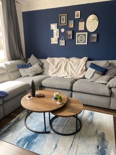 a living room with blue walls and white furniture in the corner, including a large sectional couch