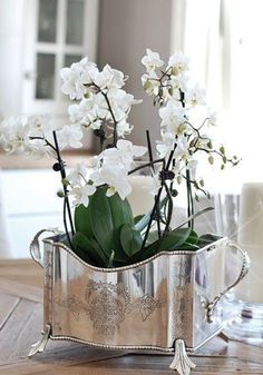 white flowers in a silver vase on a wooden table