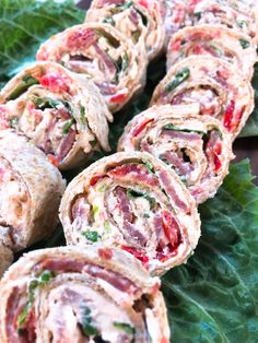 some food that is on top of a leafy green plate with the words cassar blt pinwheels