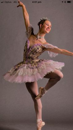 a young ballerina is posing for the camera