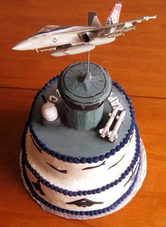 a cake that is on top of a wooden table with a plane flying over it