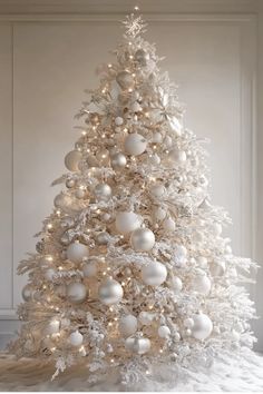 a white christmas tree with ornaments and lights